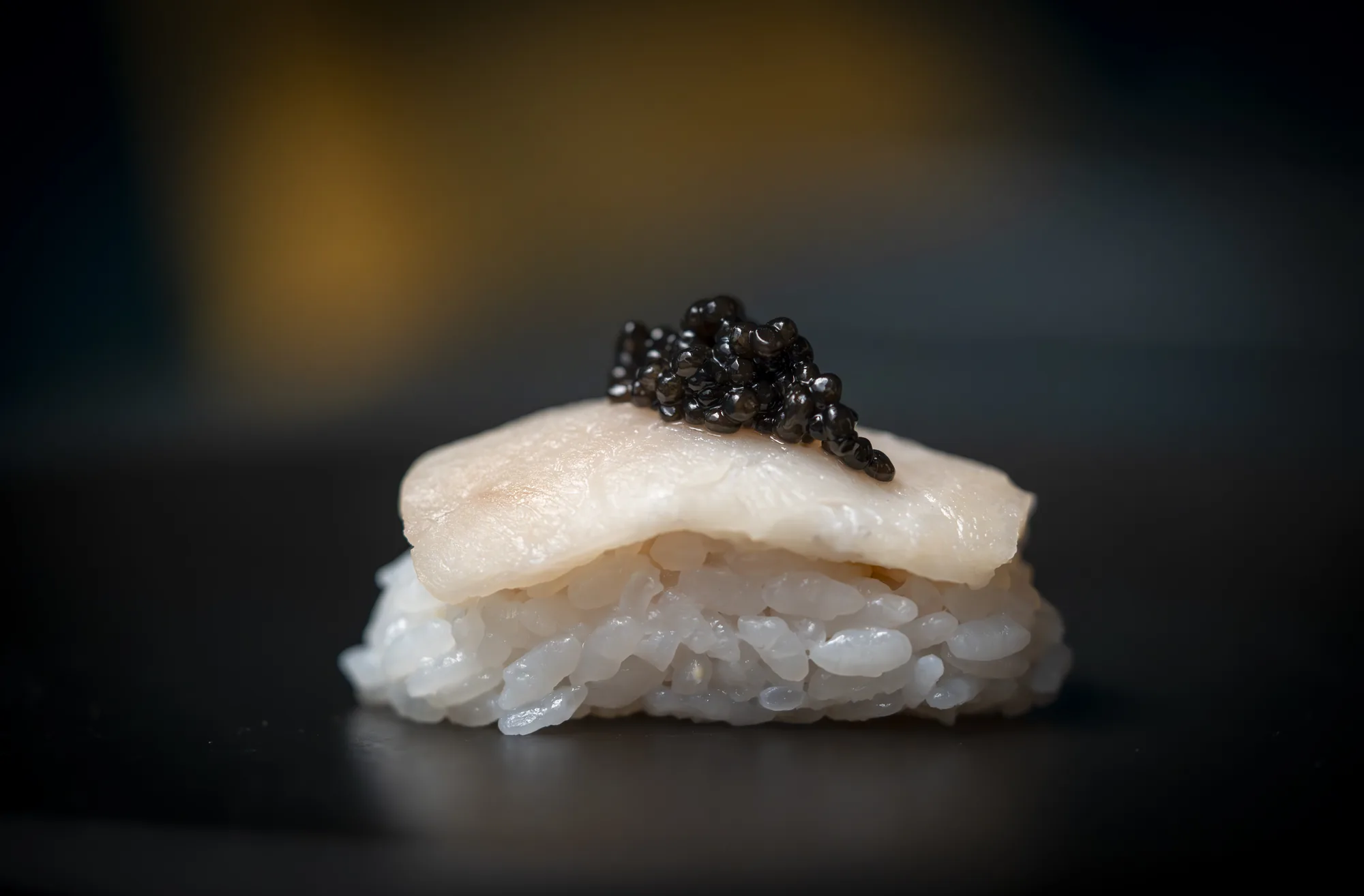 Nigiri con caviar sobre fondo negro del restaurante Oculto en Nerja