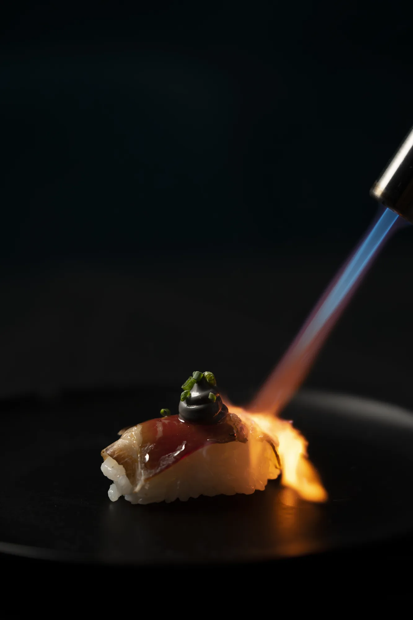 Nigiri flameado con soplete en la barra del restaurante Oculto en Nerja